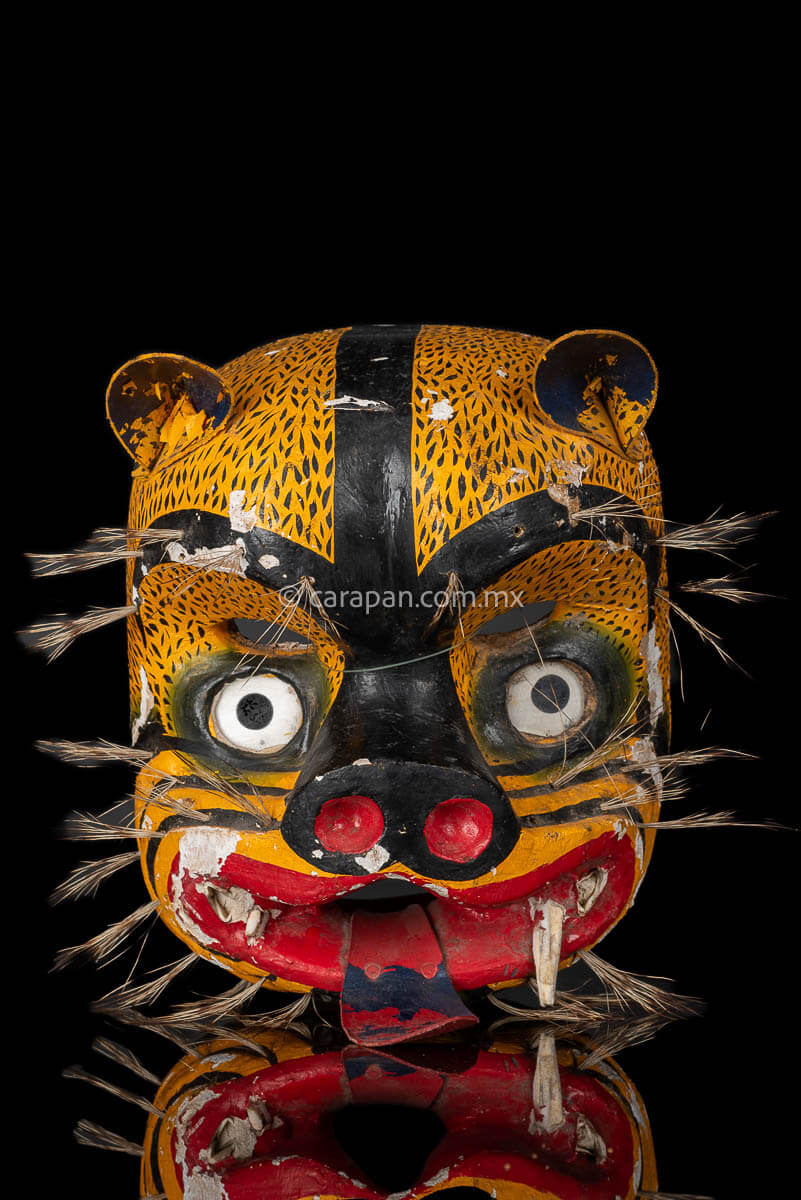 Vintage Jaguar Tecuani Mask decorated with black strokes over yellow and boar hair appliqués It has two fangs, one broken and shows use scratches