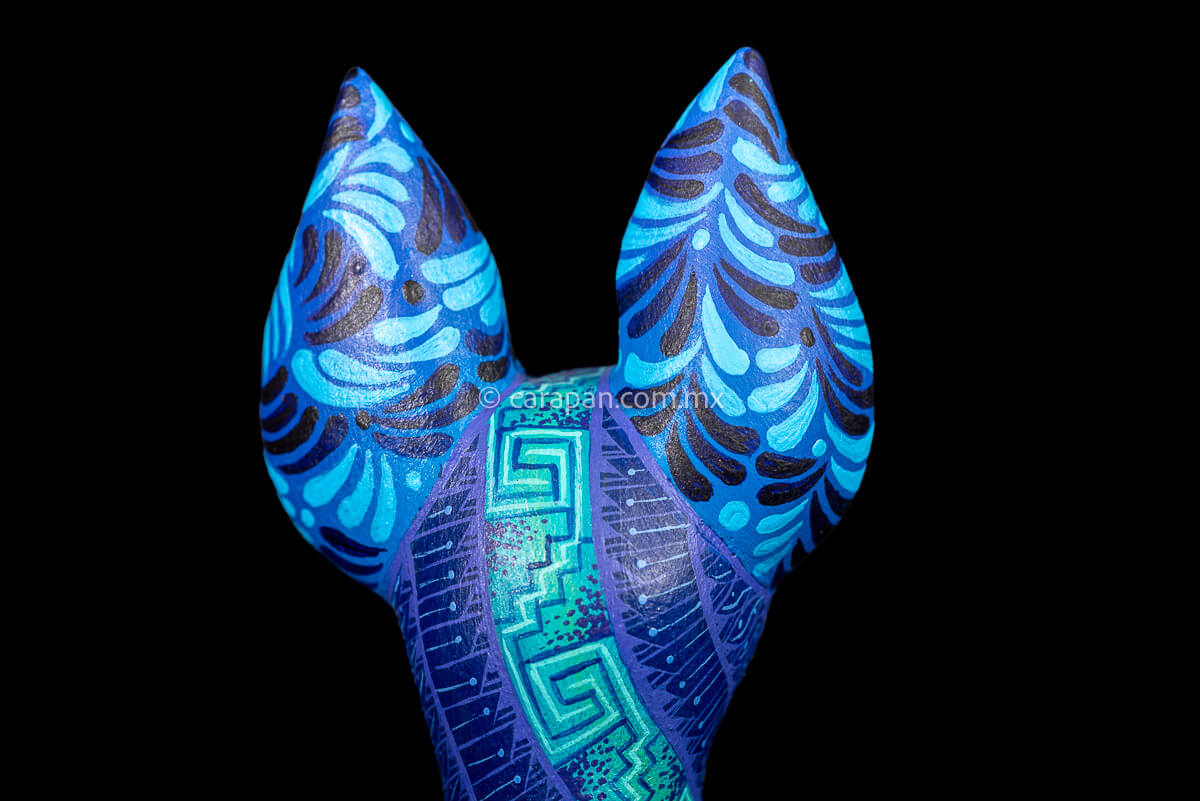 rear ears of Dog Sculpture Mexican Wood Carving Hand crafted in Oaxaca & decorated with indigenous Zapotec symbols in blue