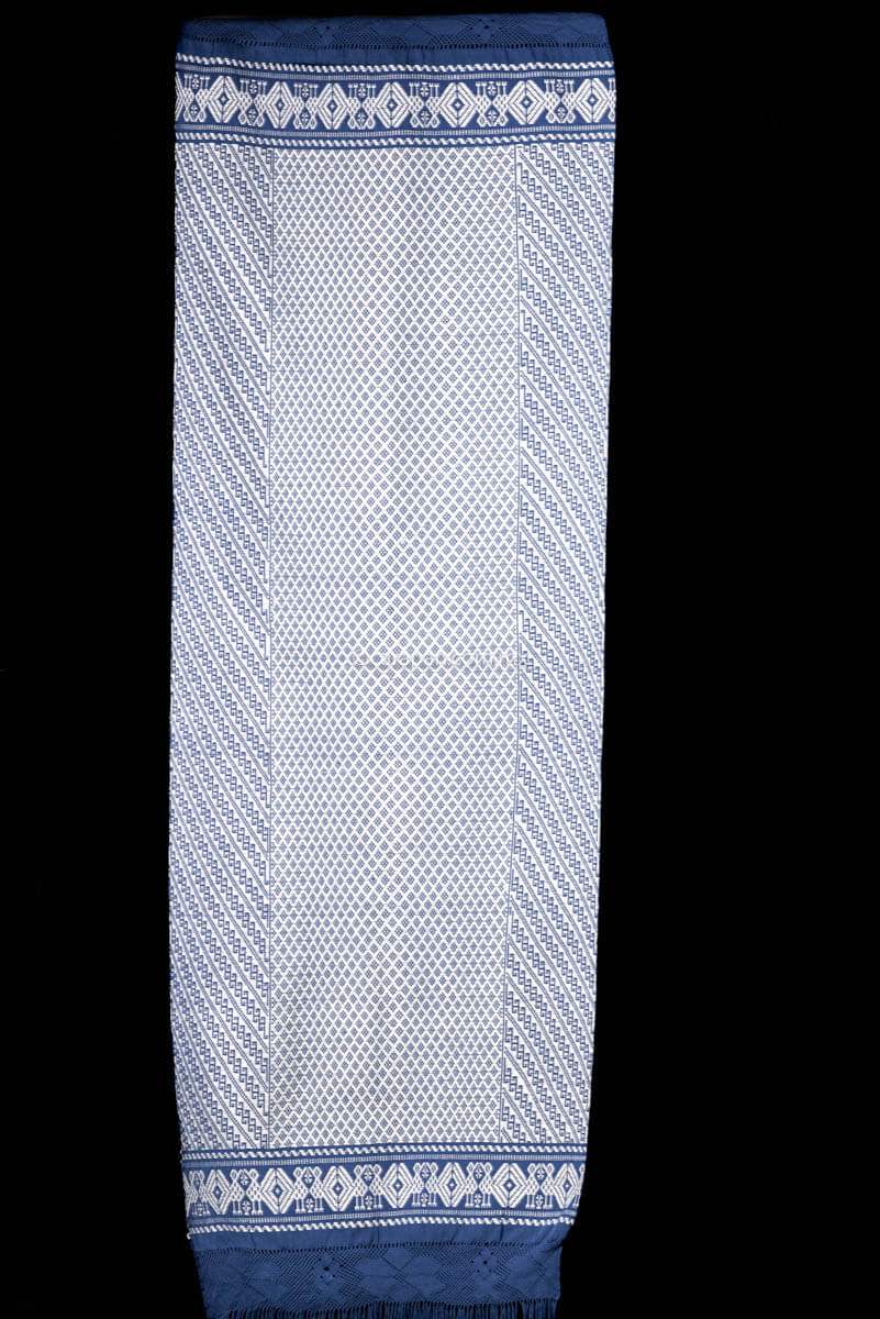 Purepecha Indigenous Textile Backstrap Loomed with mesmerizing patterns in blue and white.Reversible, in one side white dominates over blue. The other side blue dominates over white. The border is decorated with  birds and the blue fringe displays a  hand knotted openwork with flowers.