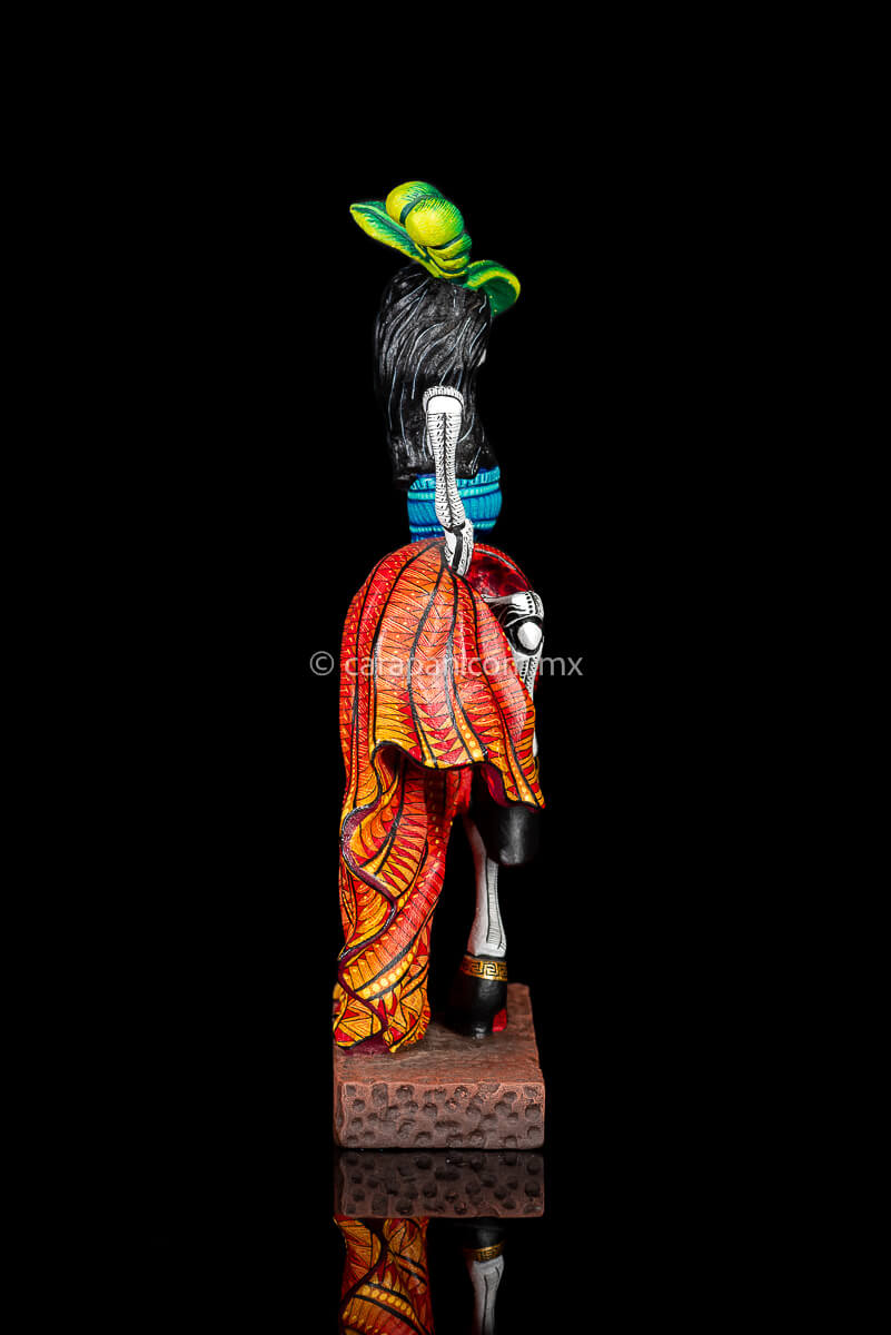 Day of the Dead Wooden Sculpture Mexican Catrina dancing can can lifting up her skirt she wears 3 feather haad dress, an orange skirt & a blue top her clothes are decoraated with zapotec symbols & the skeleton is meticulously decorated with patterns in black & White