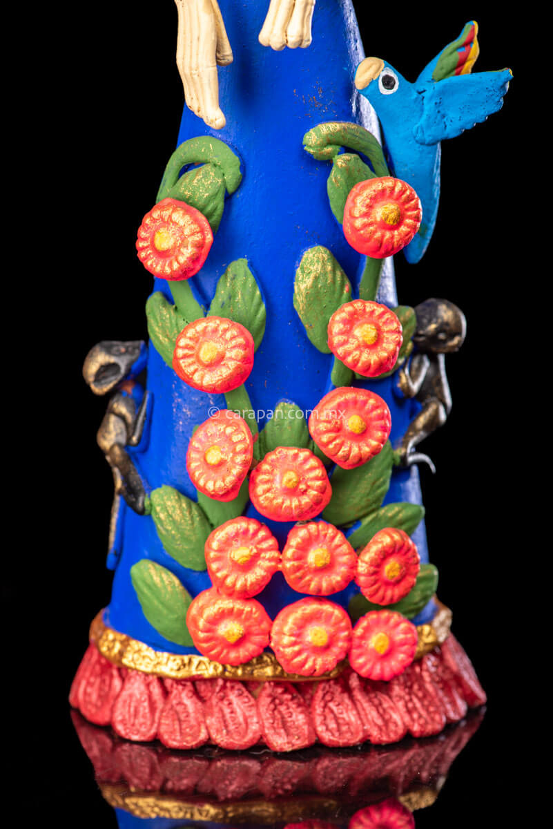 Mexican Clay Catrina Sculpture with blue dress and pink flowers. The catrina is inspired by Two of the most emblematic Frida Kahlo's self portraits with monkeys and parrots. Taht's why this catrina has three parrots and monkeys next to her. Her head dress is decorated with pink flowers and her skull is hand painted.