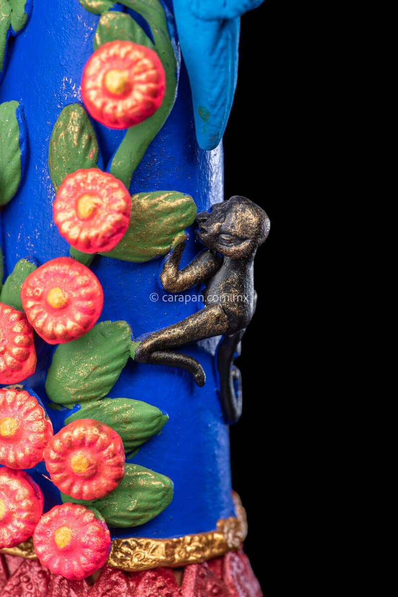 Mexican Clay Catrina Sculpture with blue dress and pink flowers. The catrina is inspired by Two of the most emblematic Frida Kahlo's self portraits with monkeys and parrots. Taht's why this catrina has three parrots and monkeys next to her. Her head dress is decorated with pink flowers and her skull is hand painted.