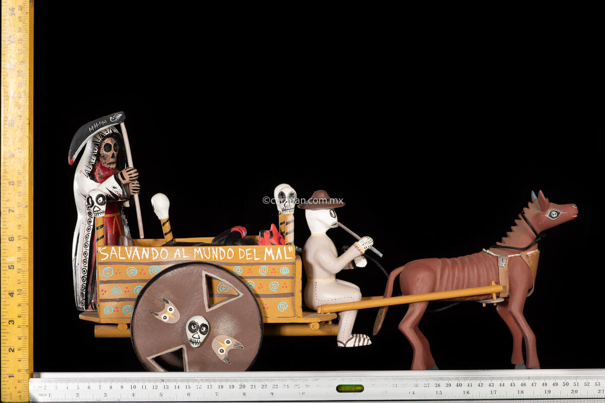Cart pulled by a brown mule with 1 skeleton as rider & a figure representing the dead on it beside a death devil. The cart displays the legend in spanish that states "saving the world from evil" on one side & "Death's cart driver on the other side"
