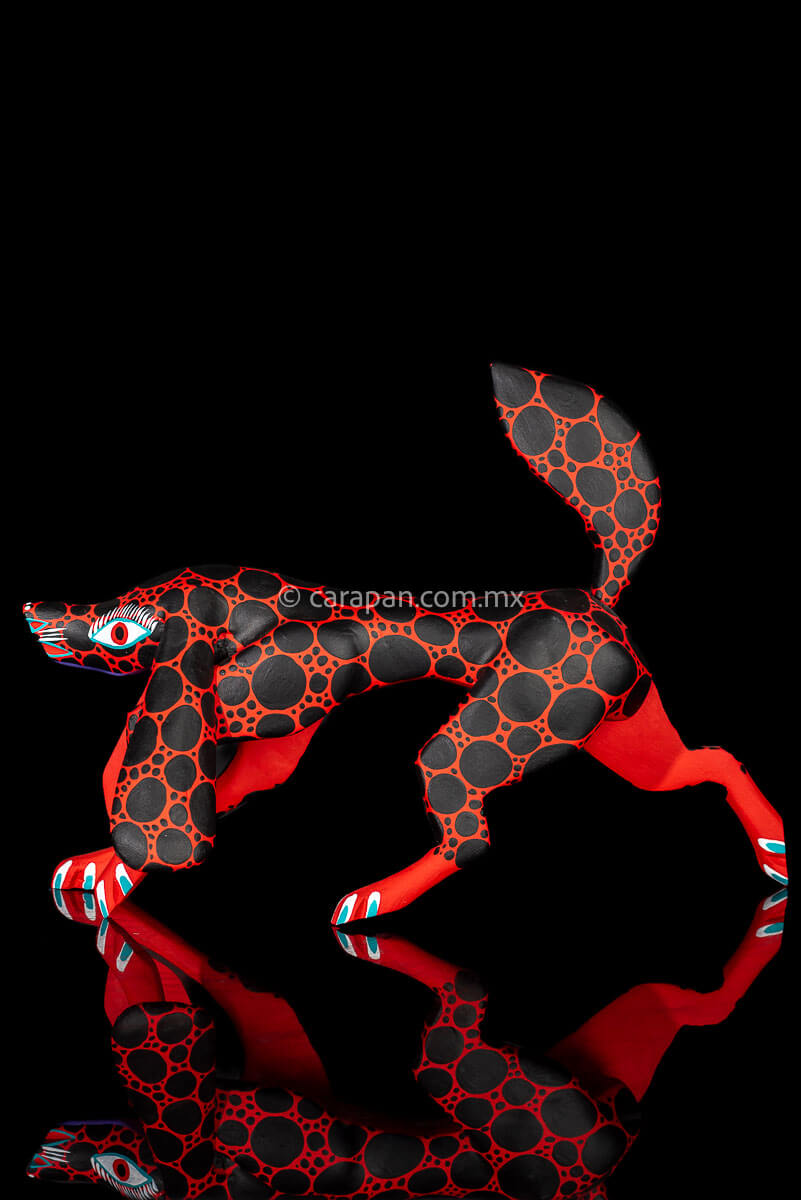 Alebrije Wood Carving Sculpture of walking dog in red with black round patches