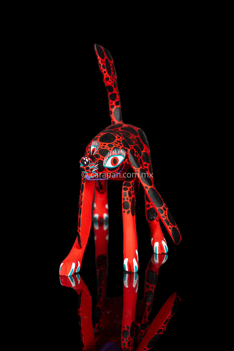 Alebrije Wood Carving Sculpture of walking dog in red with black round patches