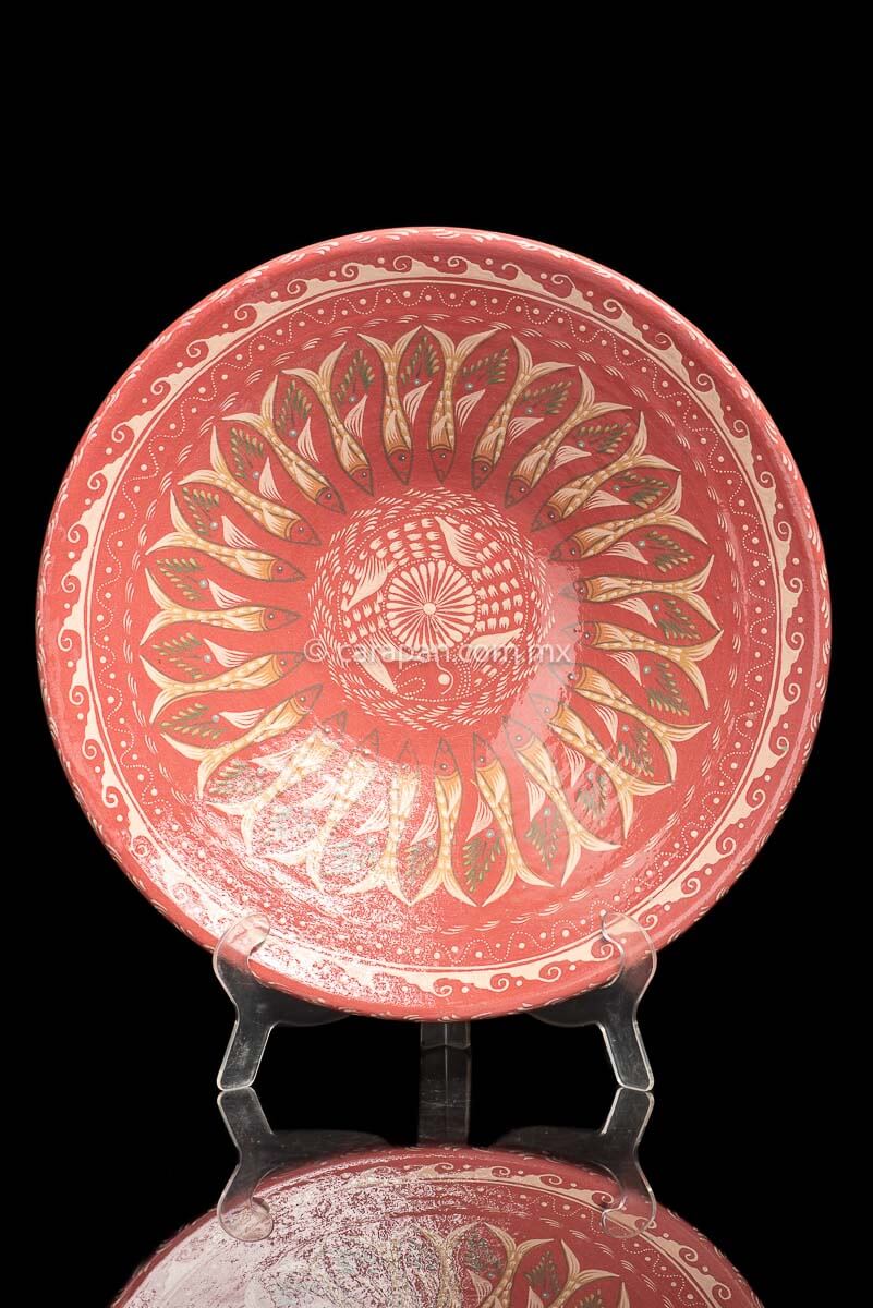 Glazed Bowl with wave pattern contour. An ensemble of many fish surround the center creating a captivating design. The center is decorated with a beige star and a fish around it