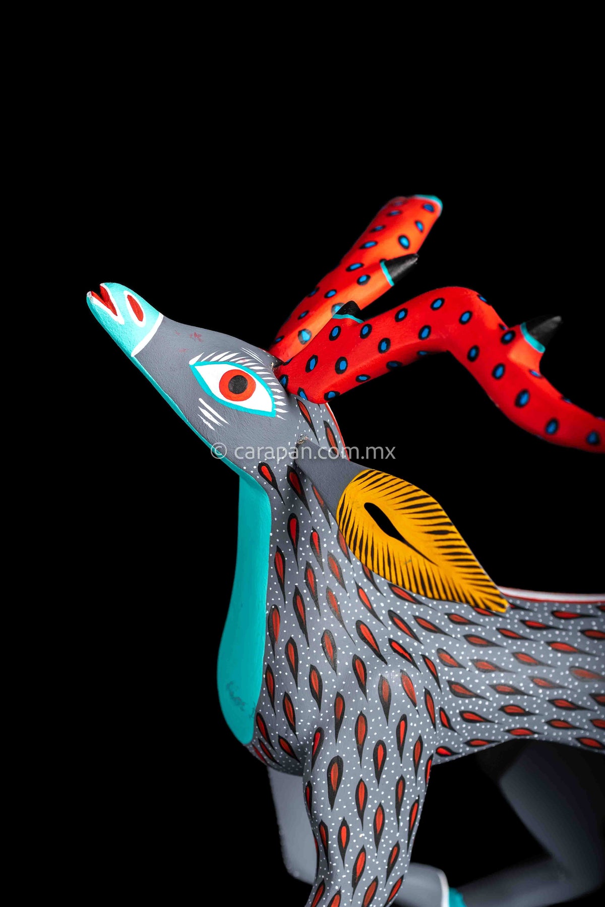 Mexican wood carving of a deer painted in gray with red strokes & white dots