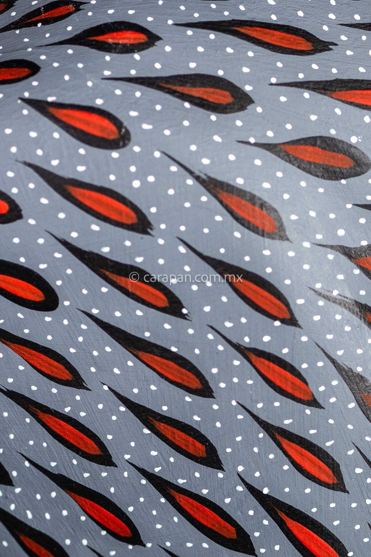 Mexican wood carving of a deer painted in gray with red strokes & white dots