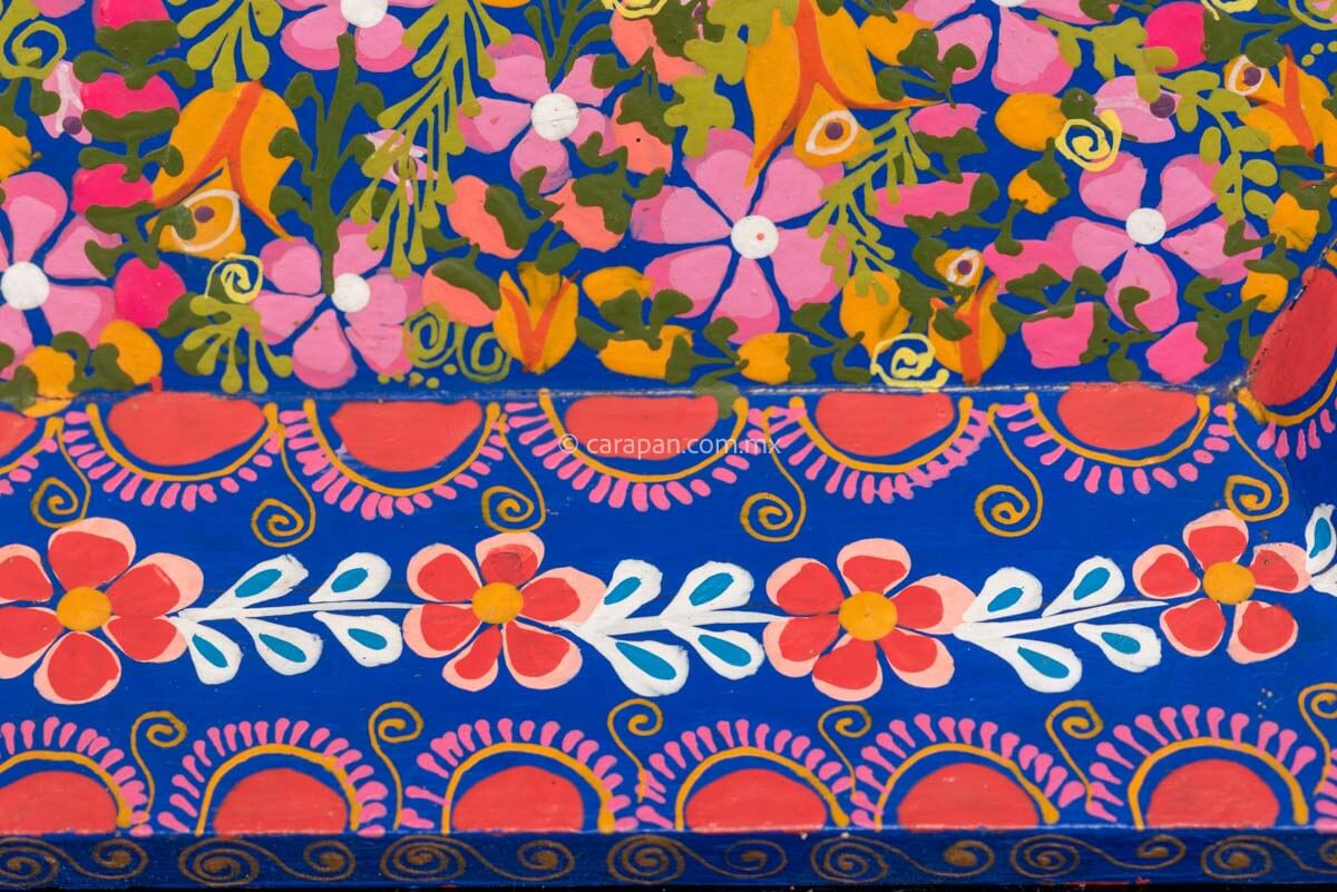 Hexagonal Wooden Tray decorated with red and pink flowers and green leafs over a blue background