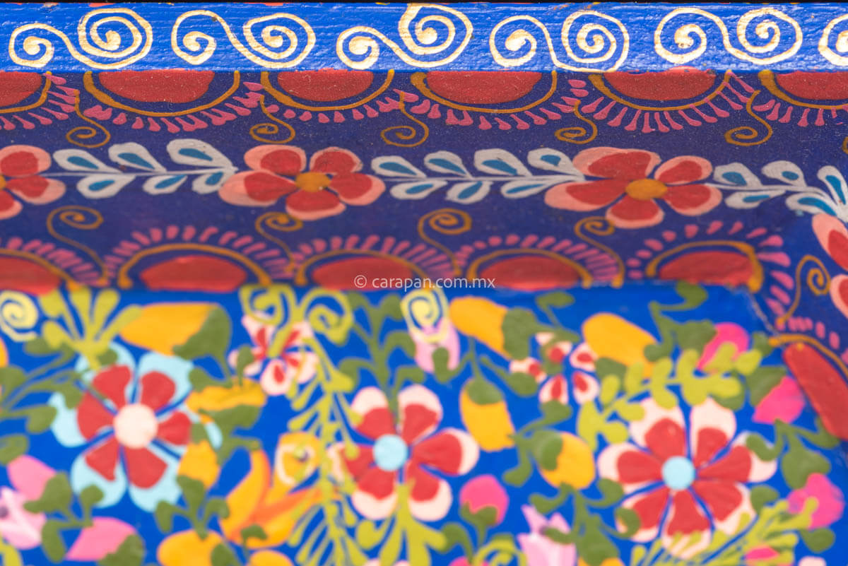 Hexagonal Wooden Tray decorated with red and pink flowers and green leafs over a blue background