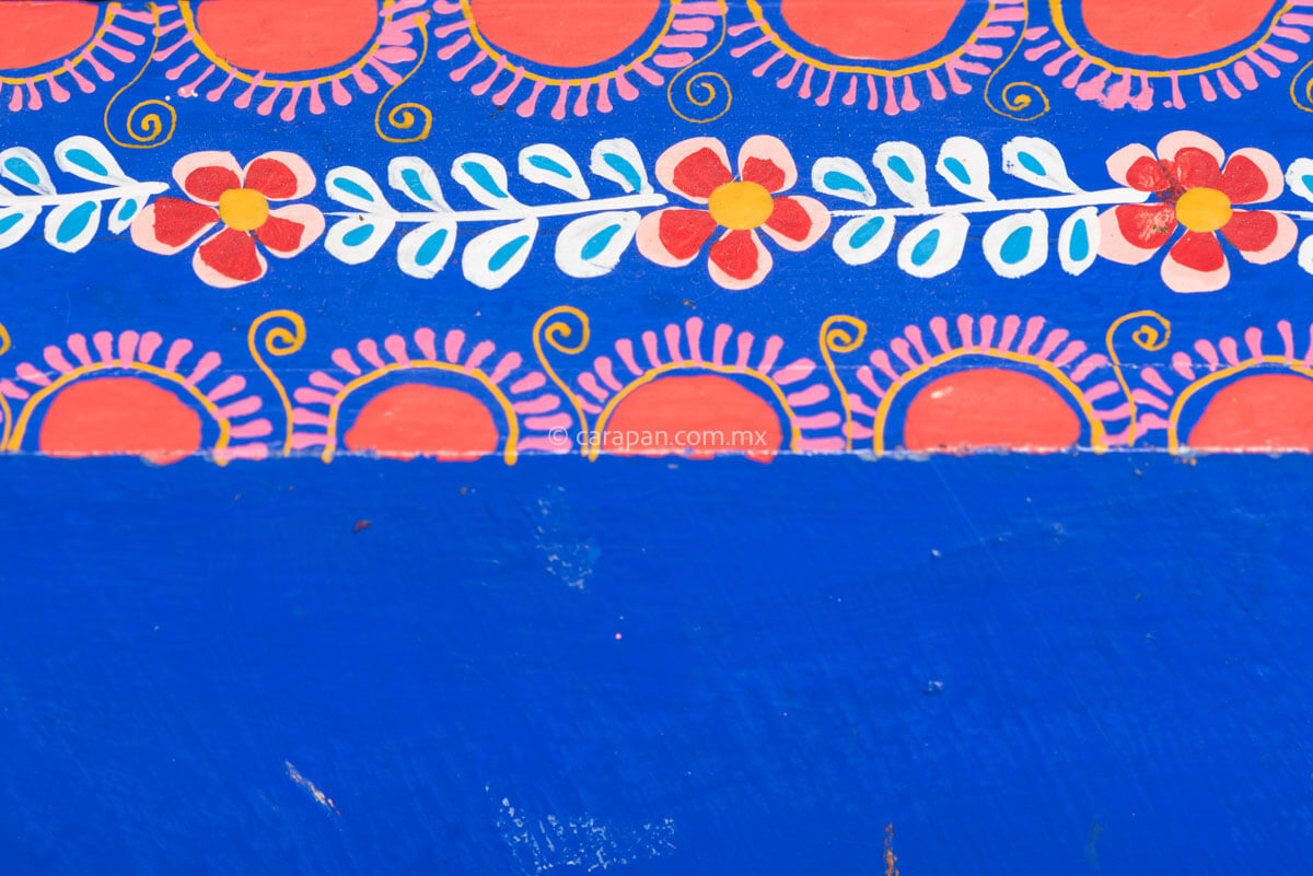 Hexagonal Wooden Tray decorated with red and pink flowers and green leafs over a blue background