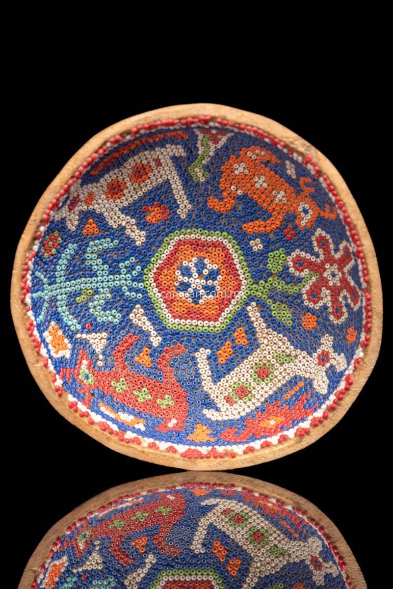 Gourd Covered with Beads with a peyote symbol at the center and two male deer and two female deer around it. It also has a flower and the corn symbol. Indigenous Huichol Art