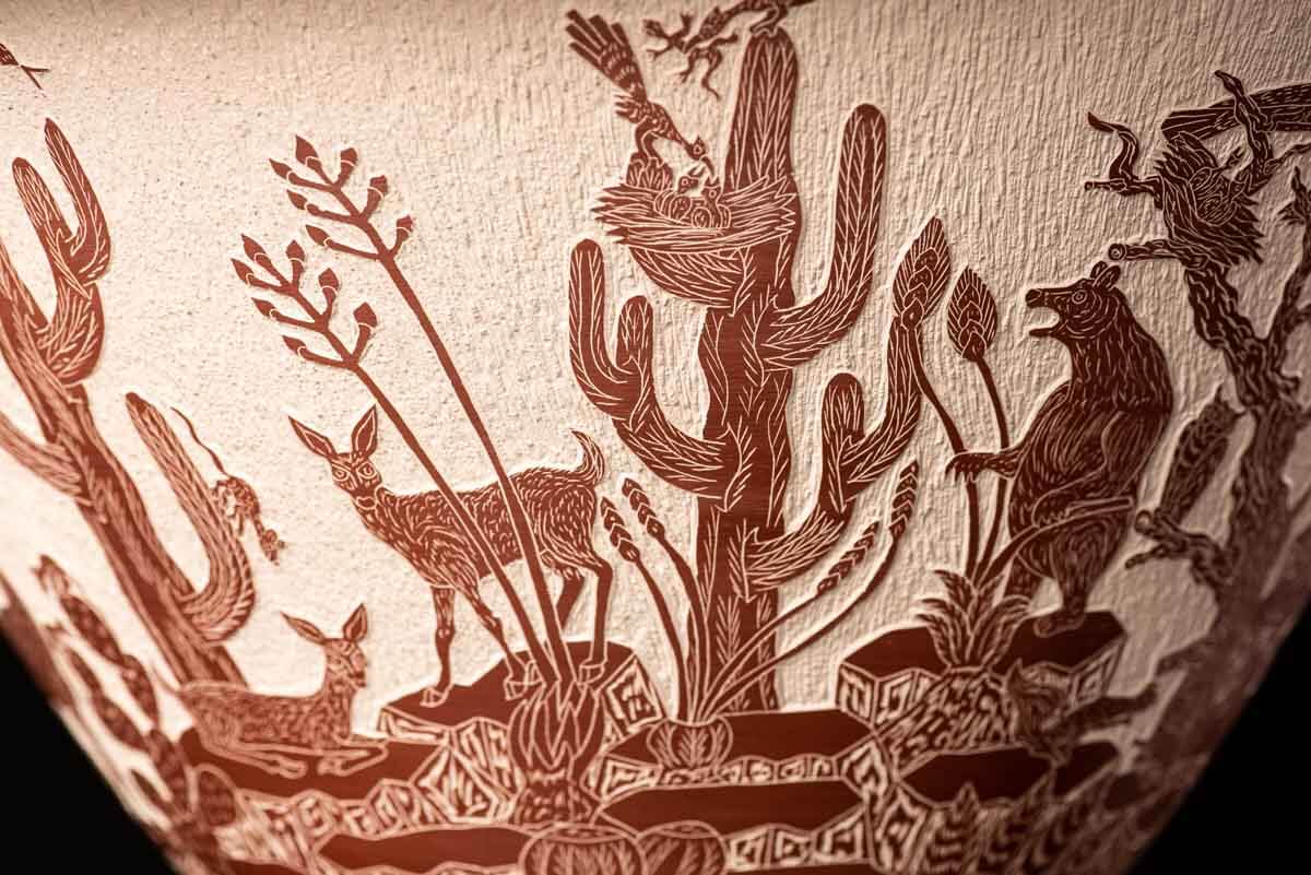 Mata Ortiz pot conic shape decorated with Mexican semi desert & Mountain creatures such as eagles, deer, rams, bats, owls, turkeys, squirrels and bears. The outside of the pot is decorated in brown over beige and the inside in black over beige. The base is also decorated in black over beige with sgraffito technique
