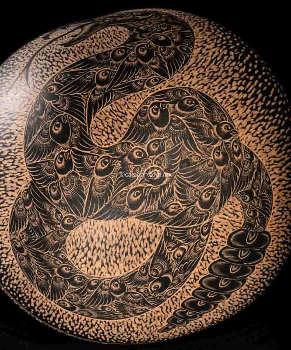 Engraved Gourd decorated with a rattlesnake. Its body is fully covered with pigeon birds. The rattlesnake body is knotted and twirled in an "S" shape