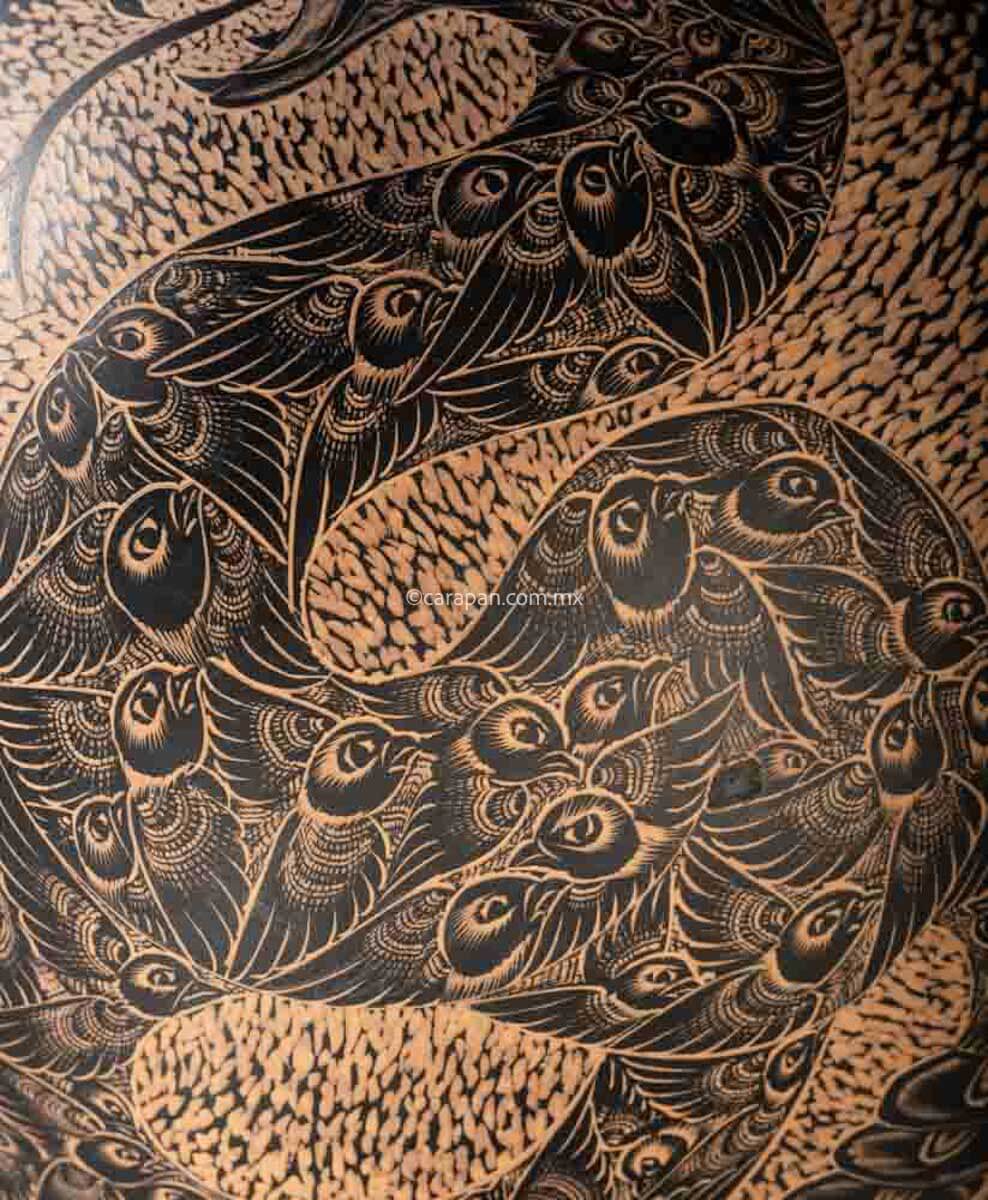 Engraved Gourd decorated with a rattlesnake. Its body is fully covered with pigeon birds. The rattlesnake body is knotted and twirled in an "S" shape