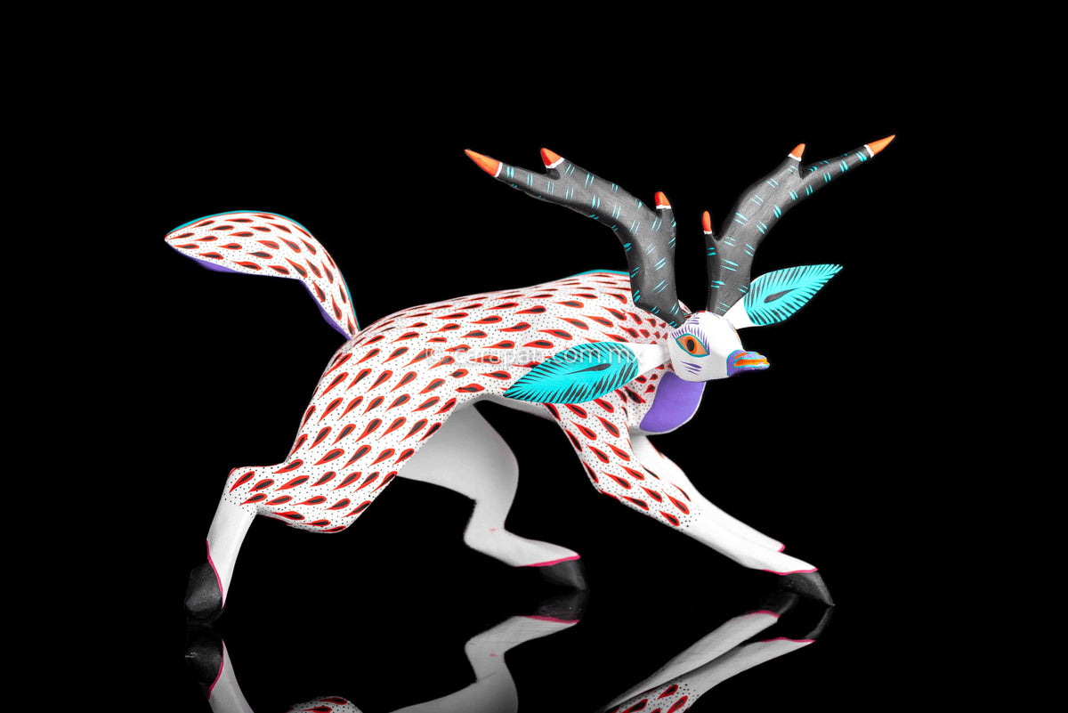 Deer Wooden Sculpture in white decorated with red strokes and small black dots. Ears, horns and tail are detachable