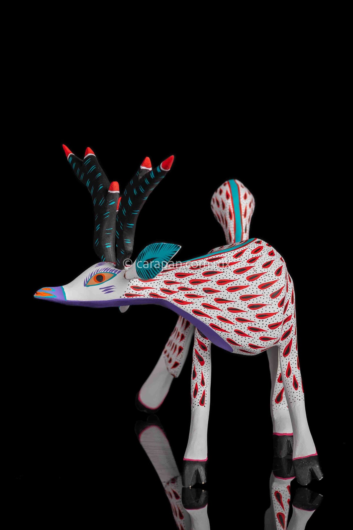 Deer Wooden Sculpture in white decorated with red strokes and small black dots. Ears, horns and tail are detachable