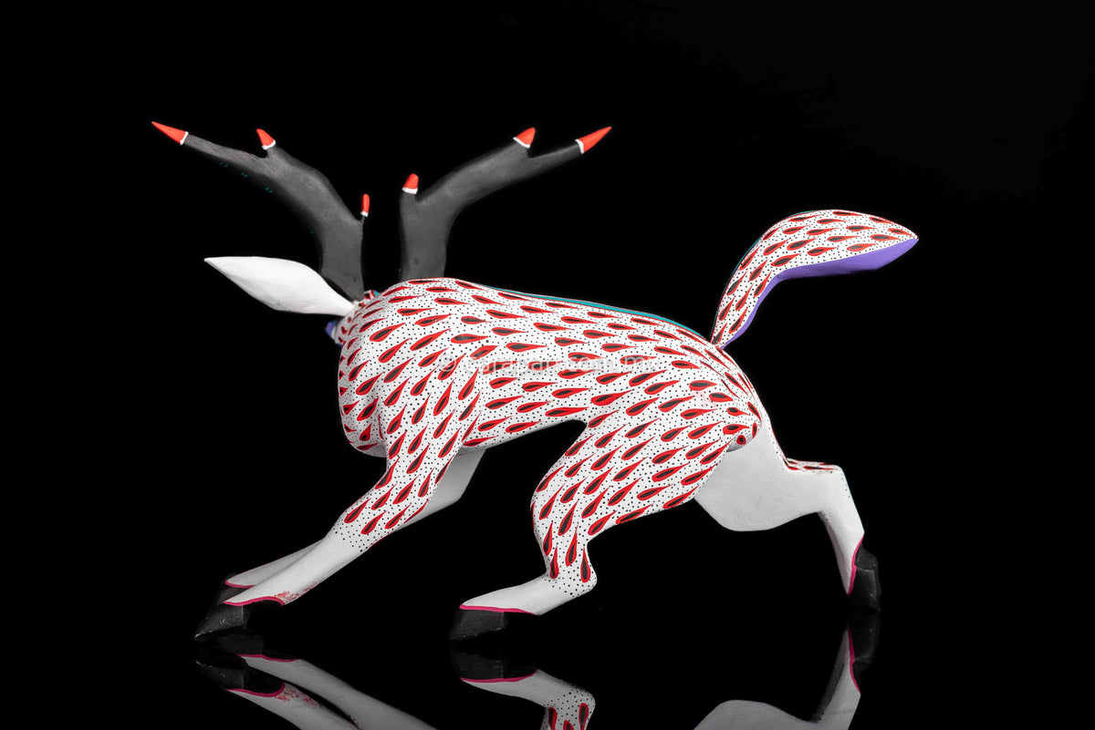 Deer Wooden Sculpture in white decorated with red strokes and small black dots. Ears, horns and tail are detachable