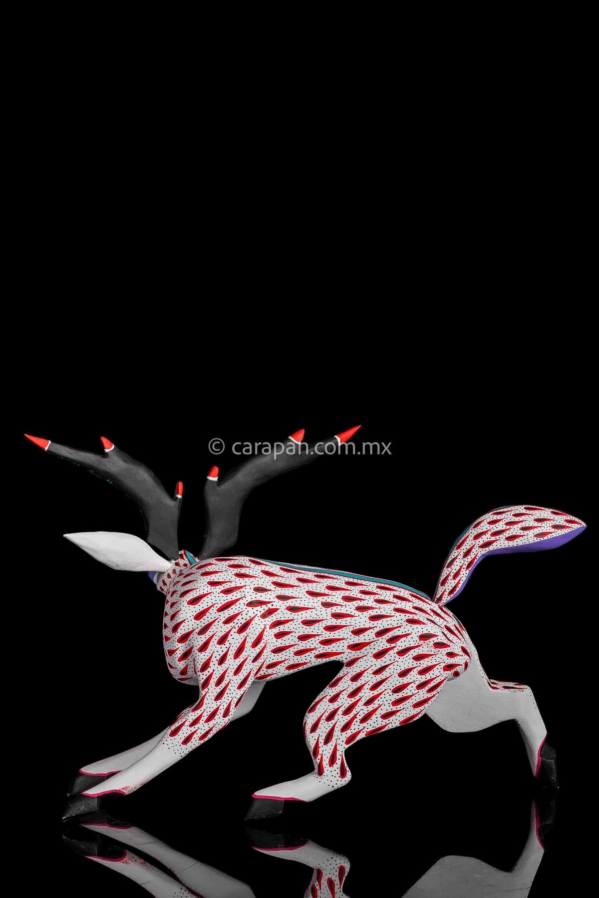 Deer Wooden Sculpture in white decorated with red strokes and small black dots. Ears, horns and tail are detachable