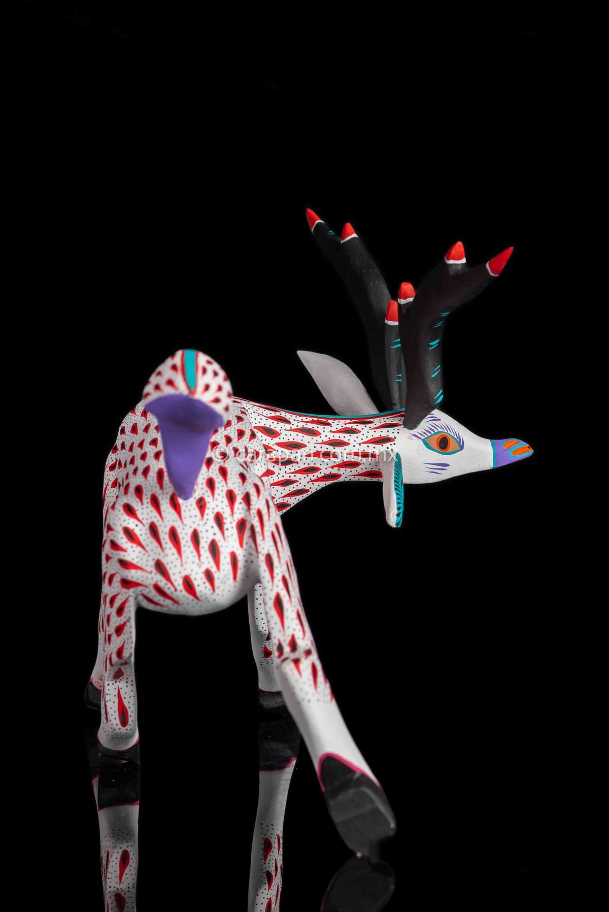 Deer Wooden Sculpture in white decorated with red strokes and small black dots. Ears, horns and tail are detachable