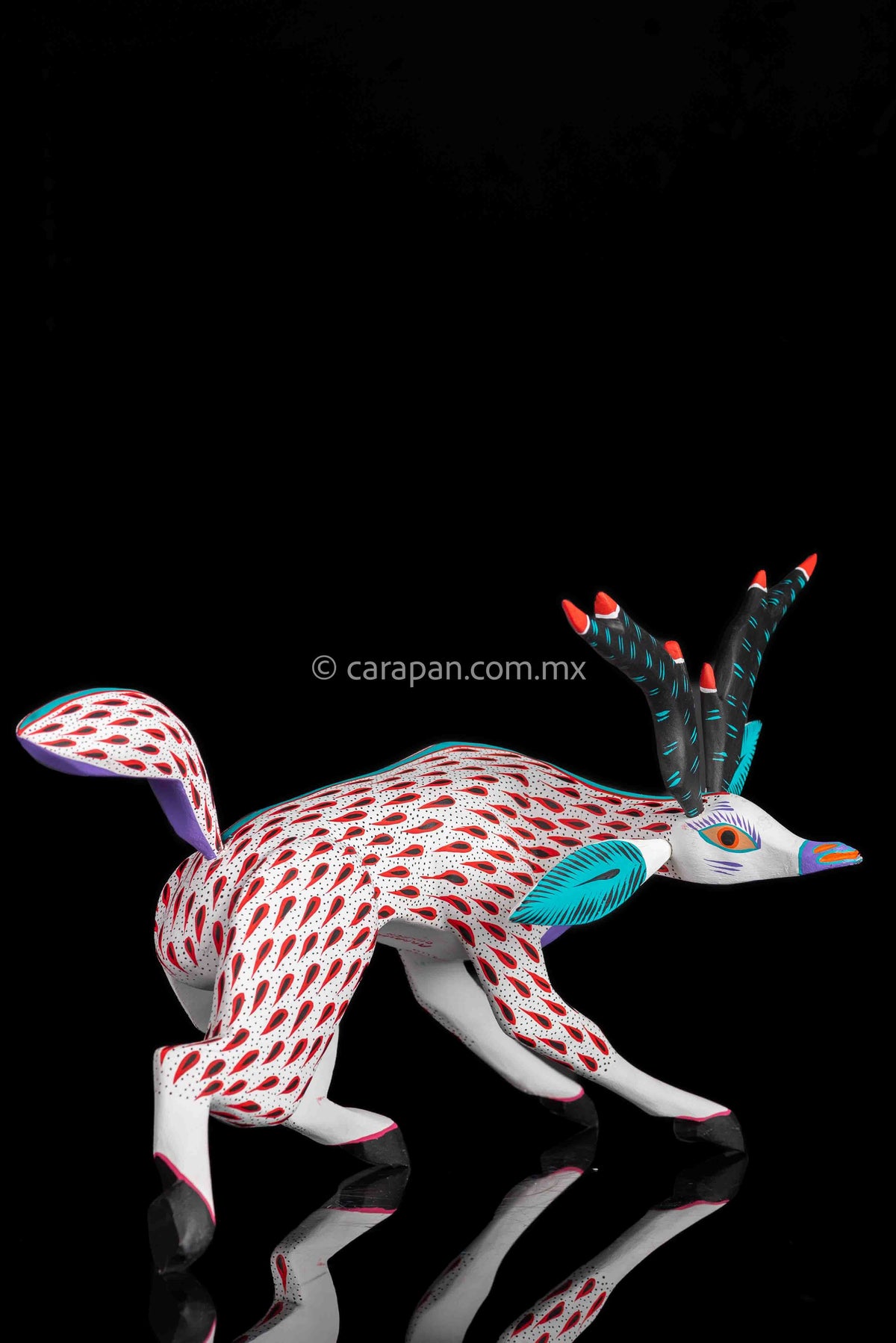 Deer Wooden Sculpture in white decorated with red strokes and small black dots. Ears, horns and tail are detachable