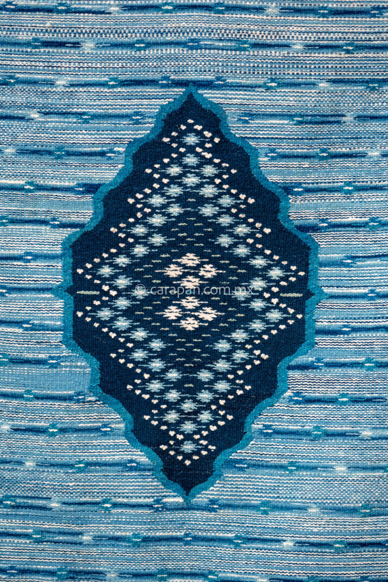 Blue Mexican Sarape made of Wool dyed with Indigo natural pigment decorated with stripes and an oval at the center filled with traditional motifs.