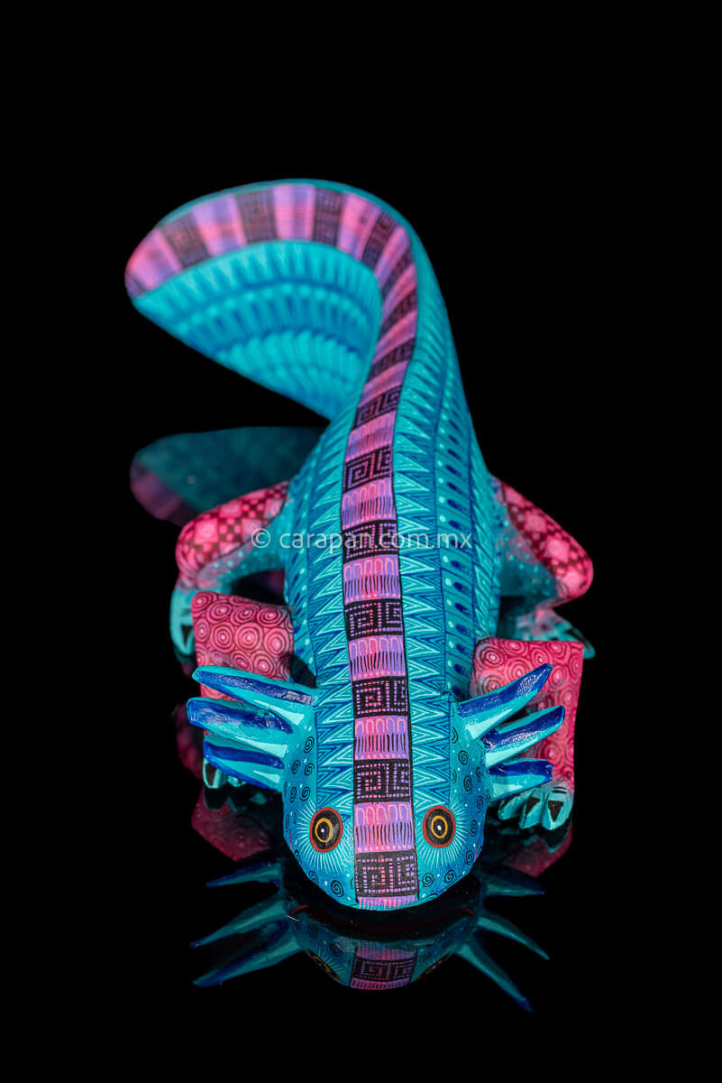 Axolotl Wood Carving from Oaxaca decorated with zapotec symbols in turquoise & a contrast fucsia over the spine and legs 