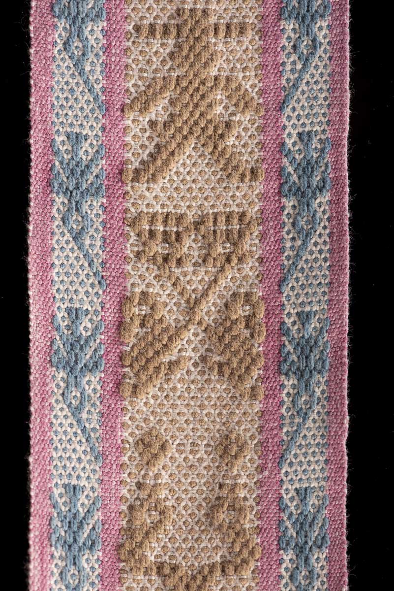 Backstrap Loomed Belt  decorated With Traditional Zapotec Figures in Brown at the center and a stripe with hummingbirds in blue with pink contour on each side One end of the belt is decorated with dolls in pink & the other with boys in blue dyed with natural pigments: Walnut, Cochineal & Indigo