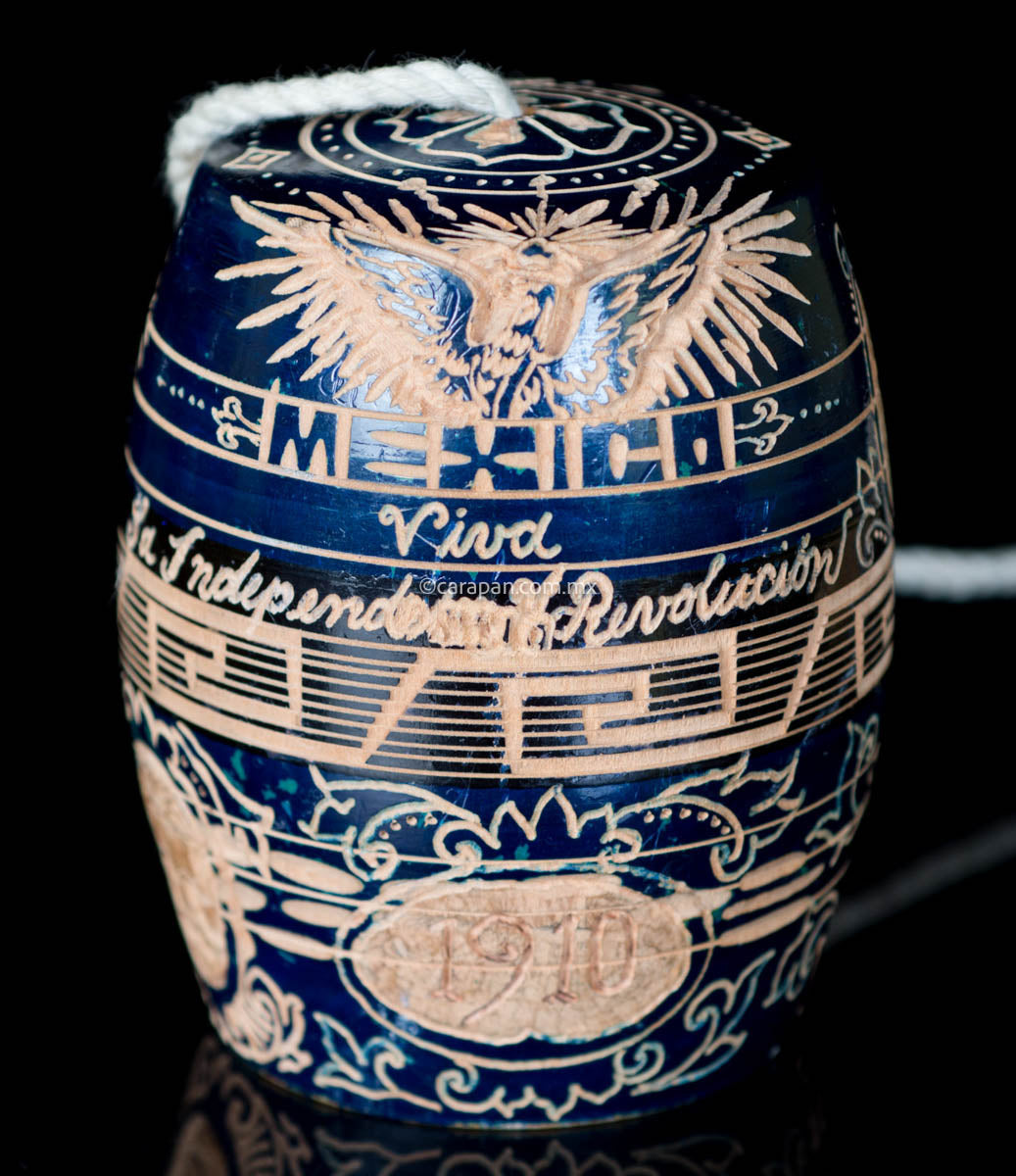 Traditional Mexican Toy Balero with Mexico's emblem on top & legend celebrating Mexico's independence and revolution.
