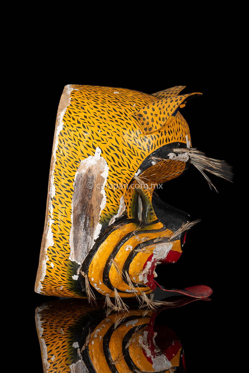 Vintage Jaguar Tecuani Mask decorated with black strokes over yellow and boar hair appliqués It has two fangs, one broken and shows use scratches 