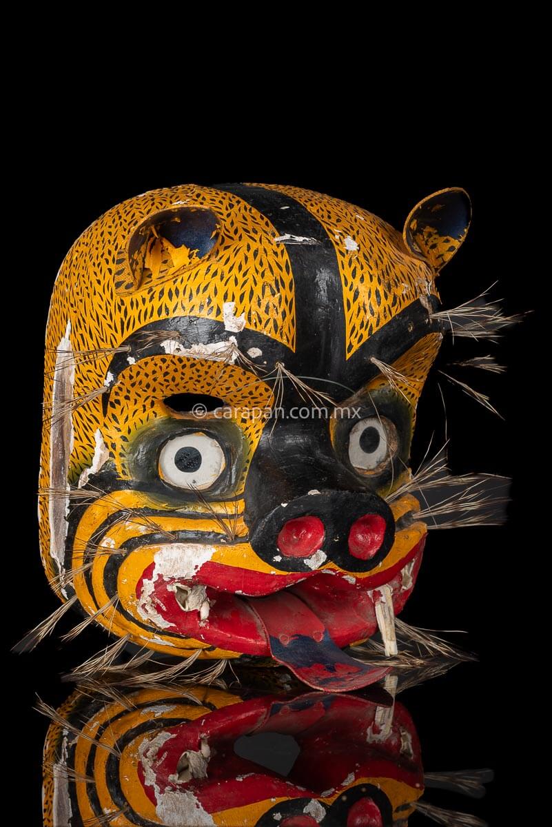 Vintage Jaguar Tecuani Mask decorated with black strokes over yellow and boar hair appliqués It has two fangs, one broken and shows use scratches 