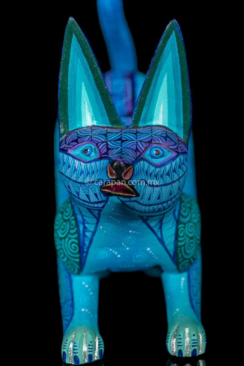 Wooden Sculpture of a Coyote Running decorated with Zapotec indigenous symbols in turquoise and blue tones 