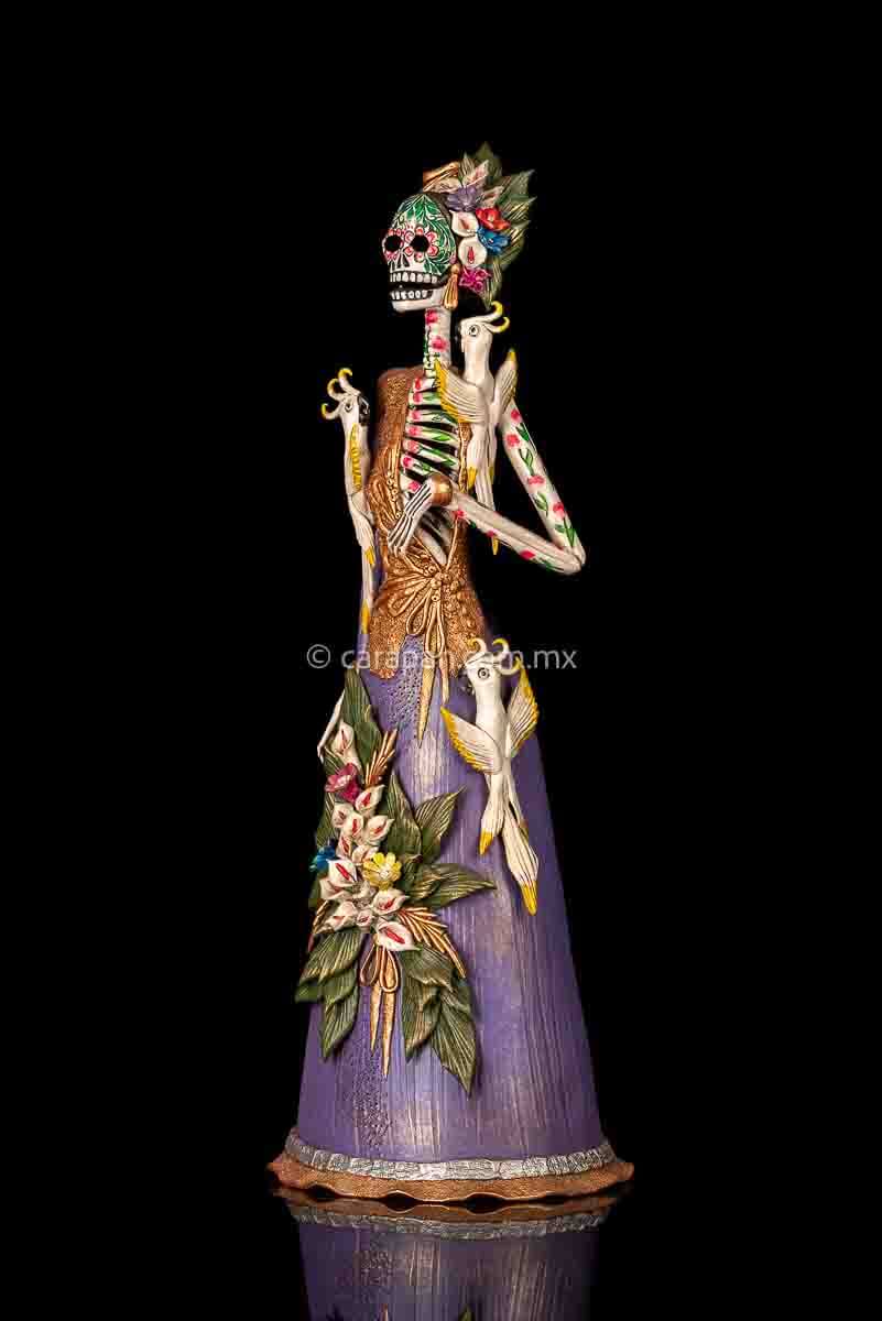 Mexican clay catrina, day of the dead sculpture with parrots and purple dress.