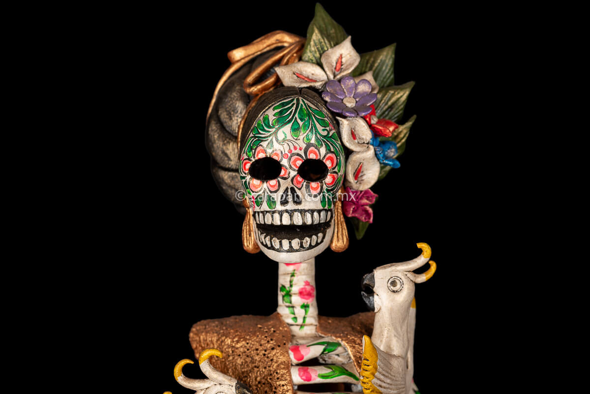 Mexican clay catrina, day of the dead sculpture with parrots and purple dress.