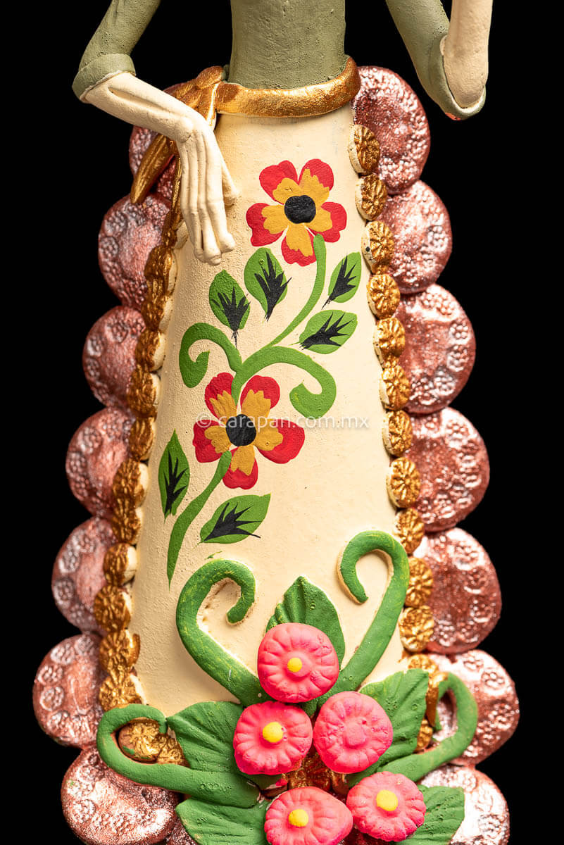 Colorful Mexican  Clay Catrina holding dish on her left hand with butterflies head dress and flowery dress  skirt