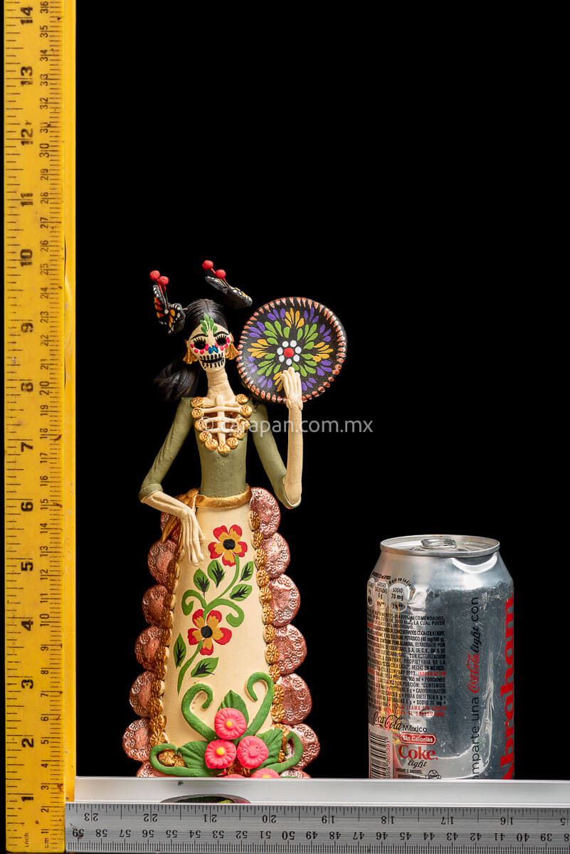 Colorful Mexican  Clay Catrina holding dish on her left hand with butterflies head dress and flowery dress rulers
