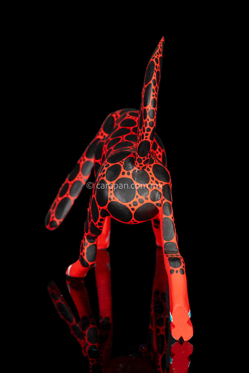Alebrije Wood Carving Sculpture of walking dog in red with black round patches