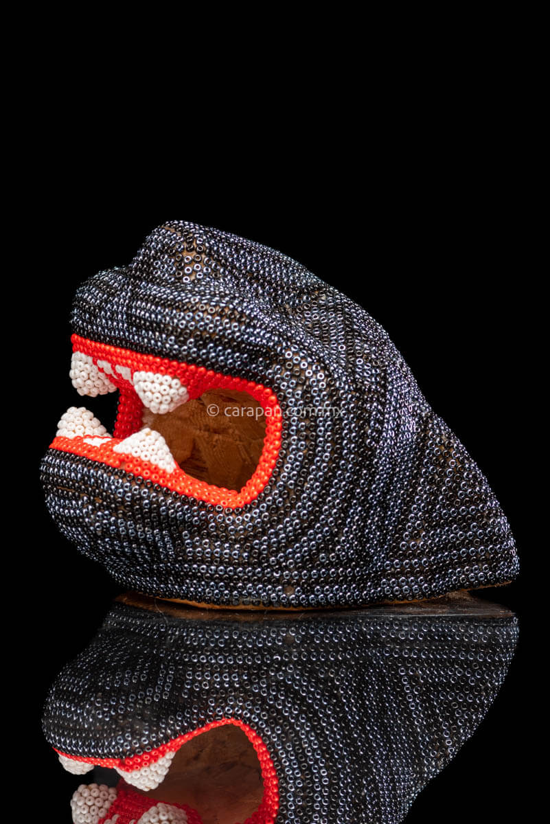 Huichol Jaguar Head Wood Carving covered with Beads in black and silver. The mouth contour is red & The fangs are white. 