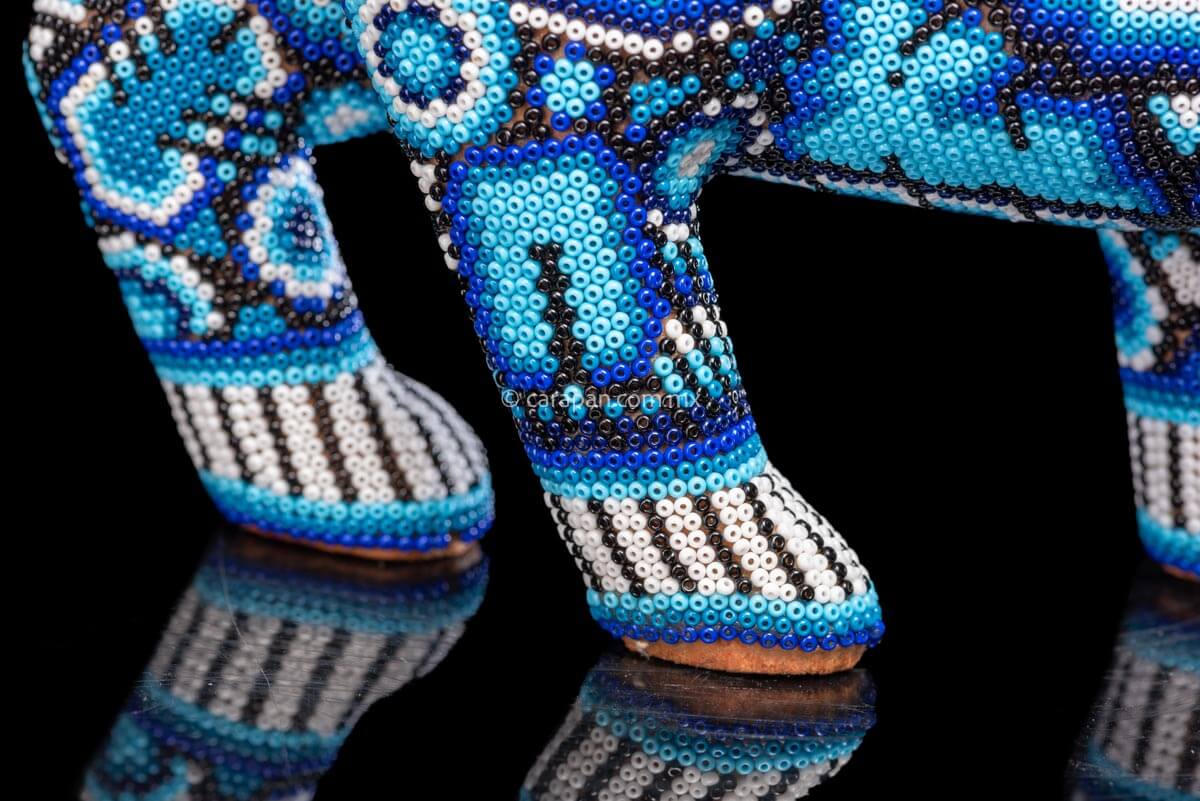 Jaguar Sculpture  Indigenous Art by Huichol People. The jaguar is decorated with beads in blue & white. The beads create a decor of huichol sacred symbols such as a candle, the peyote, the corn & the scorpion, among others. 