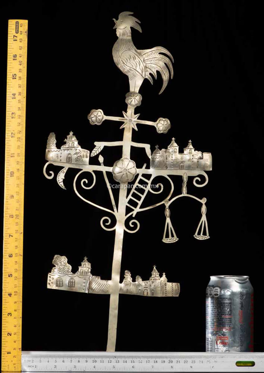 Hand chiseled Iron Cross with some elements of Christ's passion such as a rooster on top, a spear on the central left and a ladder on the central right at the far right is a balance. There are also some hand chiseled churches, perhaps representing San Cristobal de las casas, the town where this cross was made. Rulers