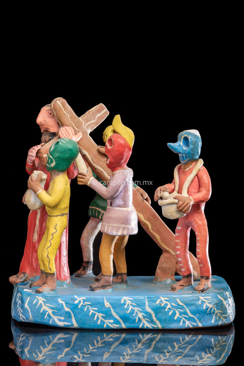 Jesus Carrying the cross escorted by 4 men wearing skull masks 