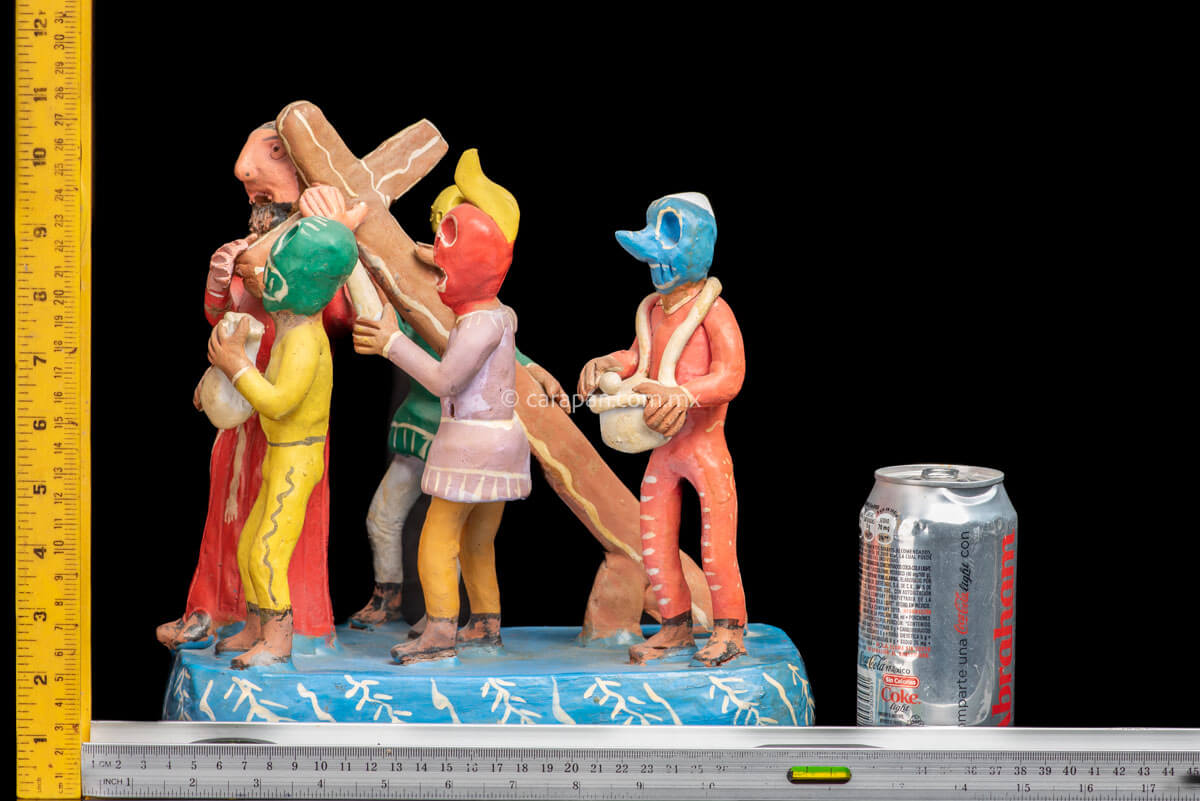 Jesus Carrying the cross escorted by 4 men wearing skull masks  rulers