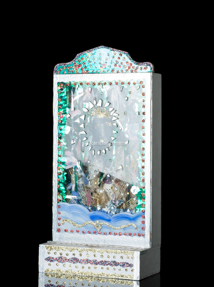 Diorama box with face of black christ wearing a golden crown. The FAce is surrounded by shiny green and silver metallic paper clipping as well as Mexican Lottery cards clipping and mirror fragments. The box is also decorated with glitter paint in gold, red and purple.