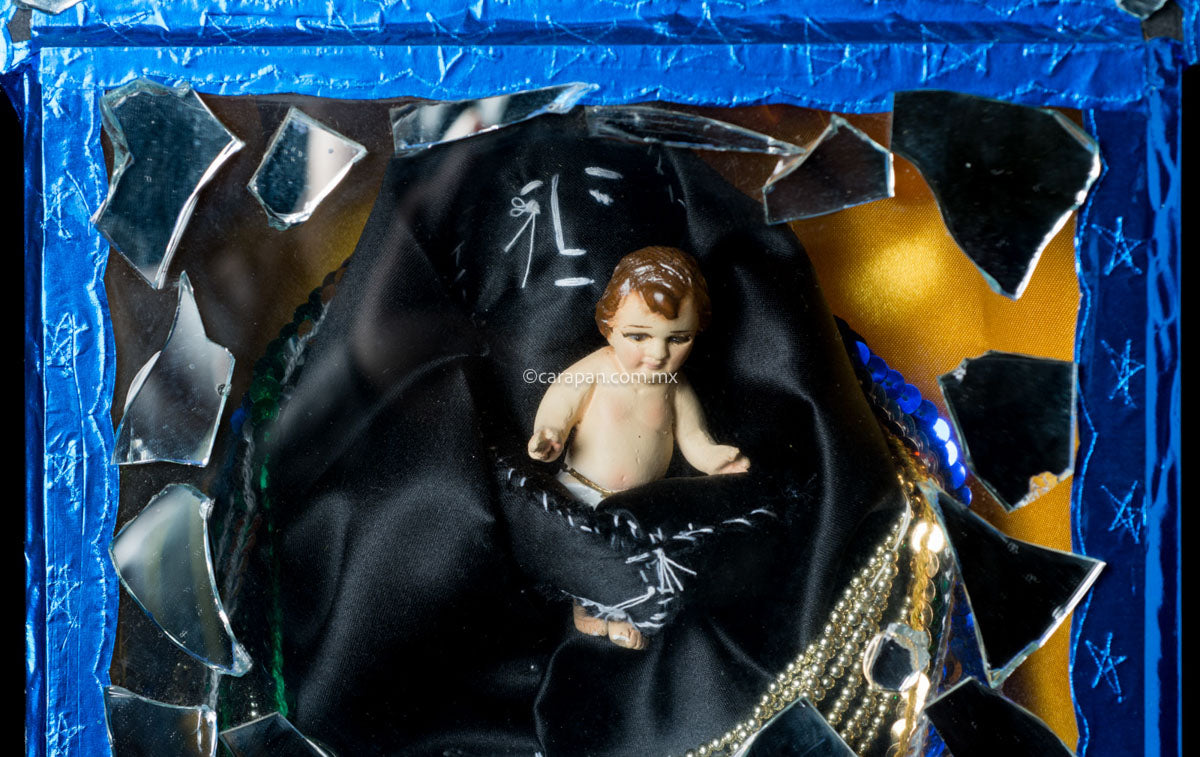 Diorama in blue with saint in black carrying baby jesus surrounded by clipping of religious images and mirror fragments. Signed 2003 By Mexican artist Alfredo Torres. 