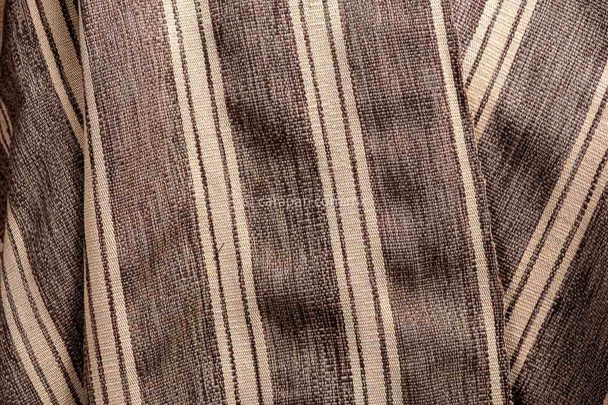 Detail of Mexican Indigenous Textile in beige with brown stripes and feathers. 