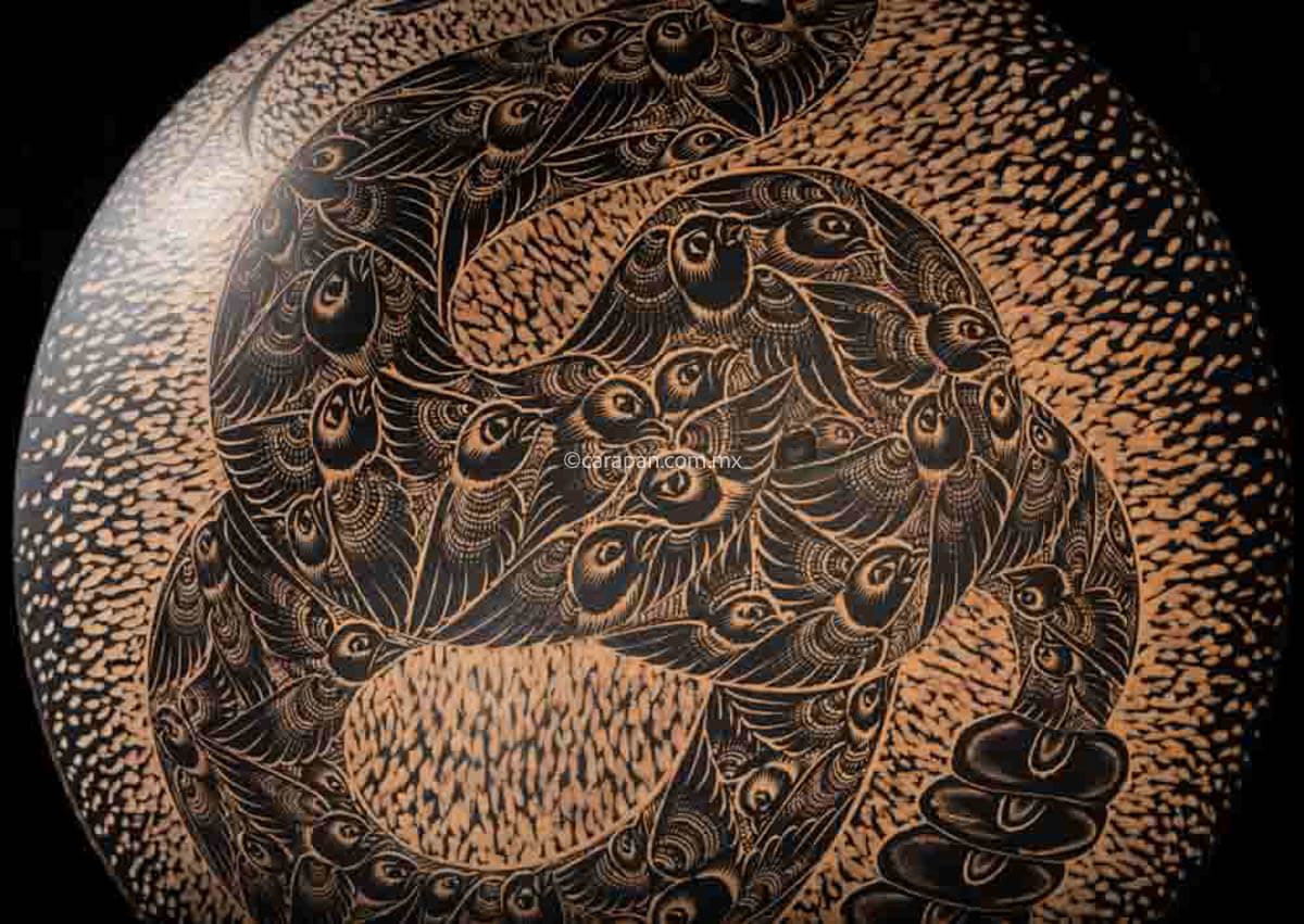 Engraved Gourd decorated with a rattlesnake. Its body is fully covered with pigeon birds. The rattlesnake body is knotted and twirled in an "S" shape