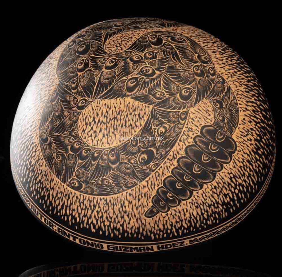 Engraved Gourd decorated with a rattlesnake. Its body is fully covered with pigeon birds. The rattlesnake body is knotted and twirled in an "S" shape