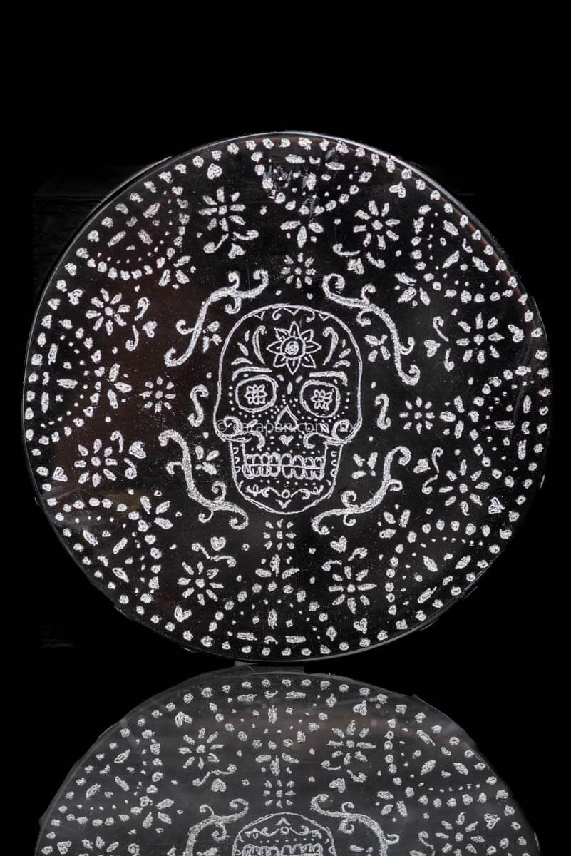 Engraved obsidian disc with skull and patterns