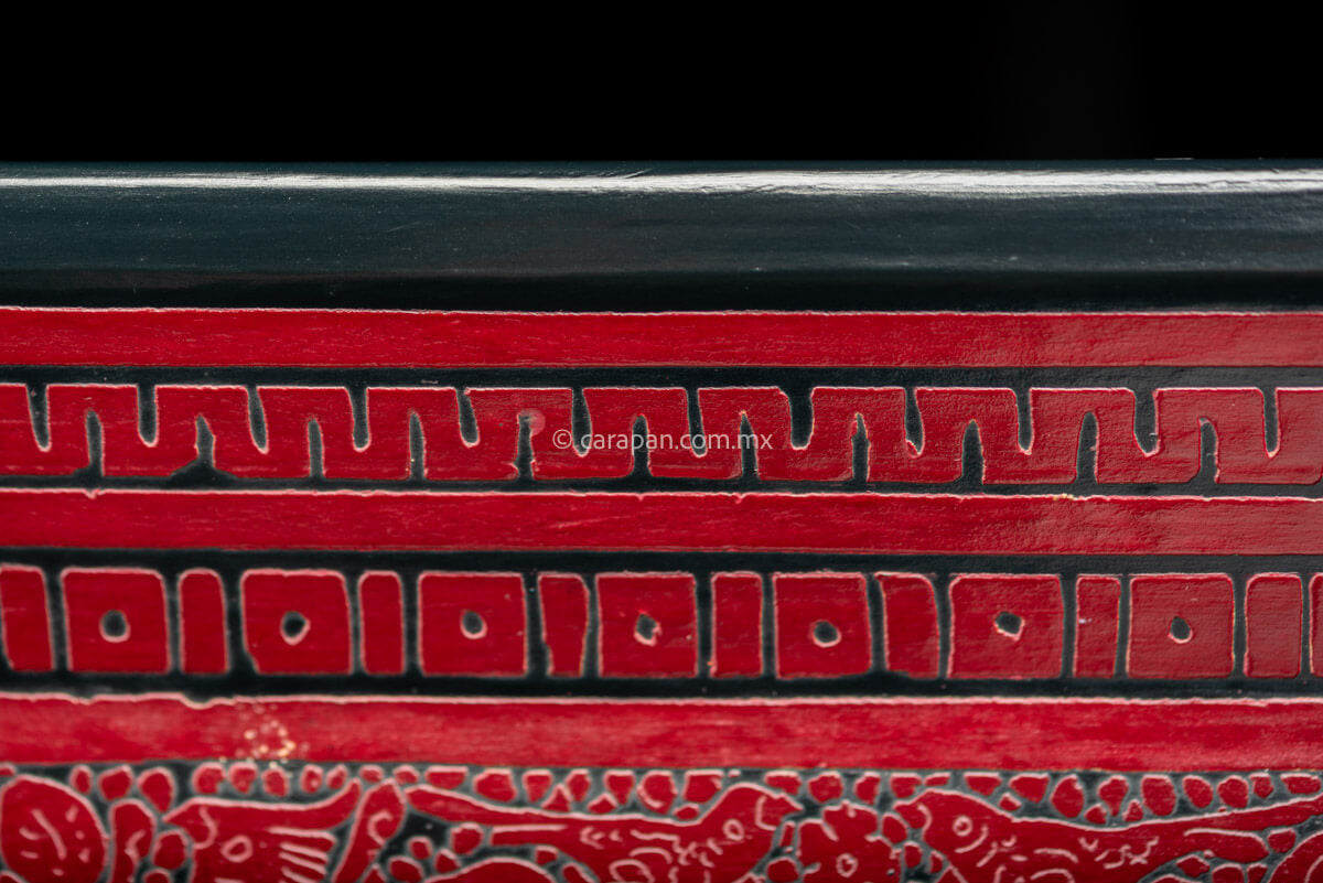 Please describe for selling Lacquered Wood Tray in etched red over black decorated profusely with  birds and vegetal motifs. The edge is framed by geometric patterns  with a thin red contour from Olinala Guerrero