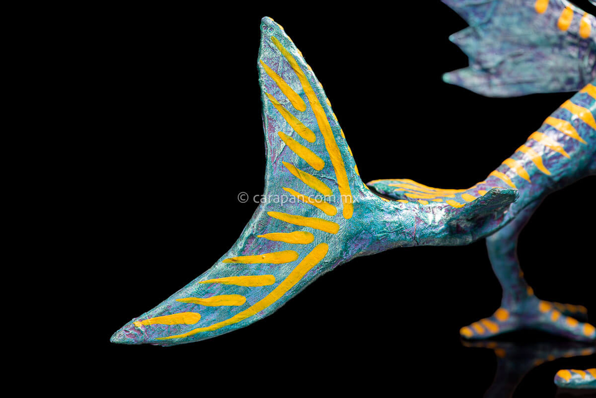 Paper Mache Alebrije inspired by sharks in teal and turquoise tones with yellow strokes, fierce open mouth showing tooth and pink tongue with blue dots. Standing on two legs  tail